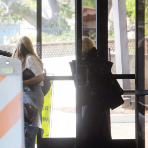 Exclusif - Madonna se déplace avec des béquilles et avec l'aide d'une assistante à la sortie d'un immeuble à Los Angeles pendant l'épidémie de coronavirus (Covid-19), le 22 juillet 2020. The ImageDirect / Bestimage