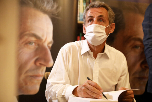 Nicolas Sarkozy arrive, en compagnie de David Lisnard (Maire de Cannes) pour la dédicace de son livre "Le temps des tempêtes" à la librairie "Autour d'un livre" à Cannes, le 24 août 2020. © Sebastien Botella / Nice Matin / Bestimage 