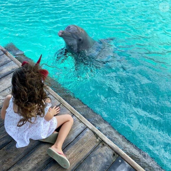 Manava, la fille de Mareva Galanter, face à un dauphin, juillet 2020