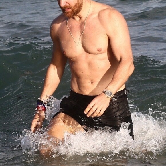 David Guetta et sa compagne Jessica Ledon, qui arbore un diamant à l'annulaire gauche, passent du bon temps sur la plage en compagnie de leur petit chien. Miami, le 23 novembre 2018.