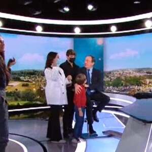 Jean-Pierre Pernaut avec ses enfants Tom et Lou, sa femme Nathalie Marquay et son petit-fils Léo sur le plateau du JT de 13h de TF1, le 18 décembre 2020