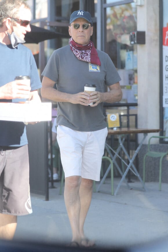 Exclusif - Bruce Willis discute et plaisante avec une passante à la sortie du restaurant "Le Pain Quotidien" avec un ami à Beverly Hills, Los Angeles. L'acteur est allé acheter un café à emporter.