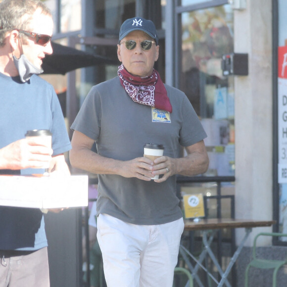 Exclusif - Bruce Willis discute et plaisante avec une passante à la sortie du restaurant "Le Pain Quotidien" avec un ami à Beverly Hills, Los Angeles, le 16 novembre 2020. L'acteur est allé acheter un café à emporter.