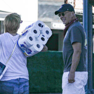 Exclusif - Bruce Willis discute et plaisante avec une passante (qui porte des rouleaux de papier toilette) à la sortie du restaurant "Le Pain Quotidien" avec un ami à Beverly Hills, Los Angeles, le 16 novembre 2020. L'acteur est allé acheter un café à emporter.