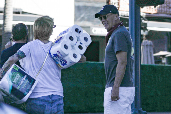 Exclusif - Bruce Willis discute et plaisante avec une passante (qui porte des rouleaux de papier toilette) à la sortie du restaurant "Le Pain Quotidien" avec un ami à Beverly Hills, Los Angeles, le 16 novembre 2020. L'acteur est allé acheter un café à emporter.