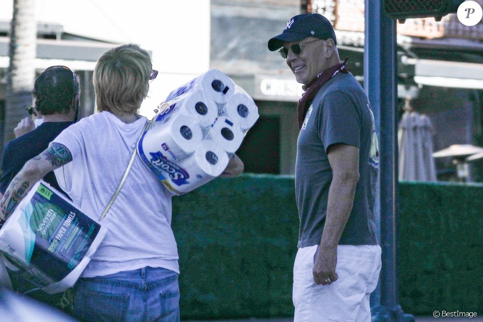 Exclusif - Bruce Willis discute et plaisante avec une passante (qui porte des rouleaux de papier toilette) à la sortie du restaurant "Le Pain Quotidien" avec un ami à Beverly Hills, Los Angeles, le 16 novembre 2020. L'acteur est allé acheter un café à emporter.