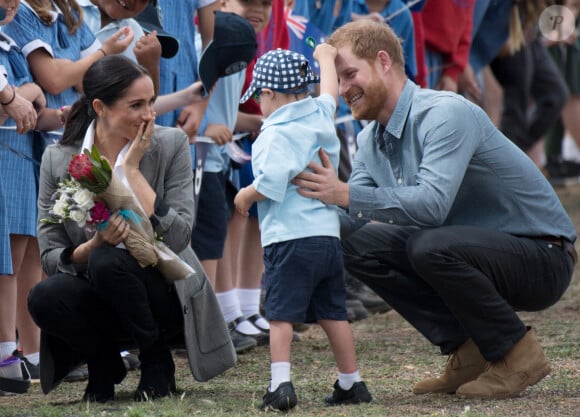 Le prince Harry, duc de Sussex et sa femme Meghan Markle, duchesse de Sussex (enceinte), accueillis par des élèves australiens à leur arrivée à Dubbo, le 17 octobre 2018.