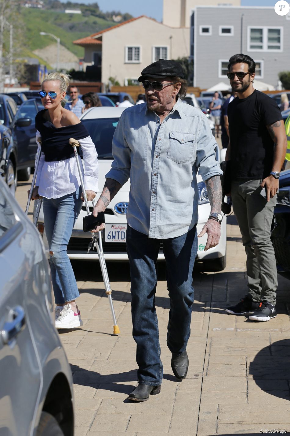 Johnny Hallyday avec sa femme Laeticia, qui marche toujours avec des béquilles, accompagnés de Maxim Nucci (Yodelice), arrivent au restaurant "Soho House" à Malibu, le 09 mars 2017.