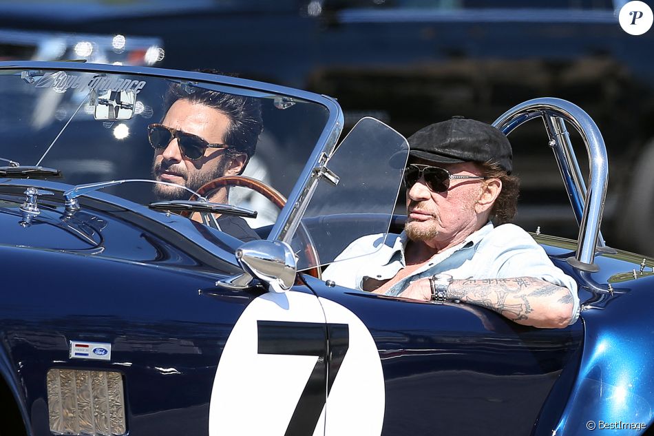 Johnny Hallyday accompagné de Maxim Nucci (Yodelice), arrive au restaurant "Soho House" à Malibu, au volant de son cabriolet AC Cobra marqué de son chiffre porte-bonheur, le numéro 7. Laeticia Hallyday, toujours en béquilles, les rejoint dans une autre voiture. Malibu, le 09 mars 2017.