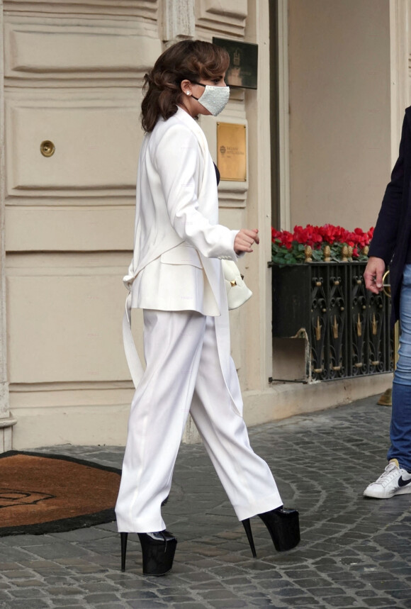 Lady Gaga quitte son hôtel, sublime en costume blanc Max Mara et bottines à plateformes. Rome, le 4 mars 2021.