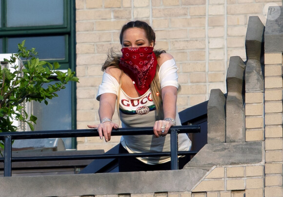 Exclusif - Mariah Carey, masquée en raison de l'épidémie de coronavirus (Covid-19), applaudit depuis son balcon pour remercier les soignants à New York, le 7 mai 2020.