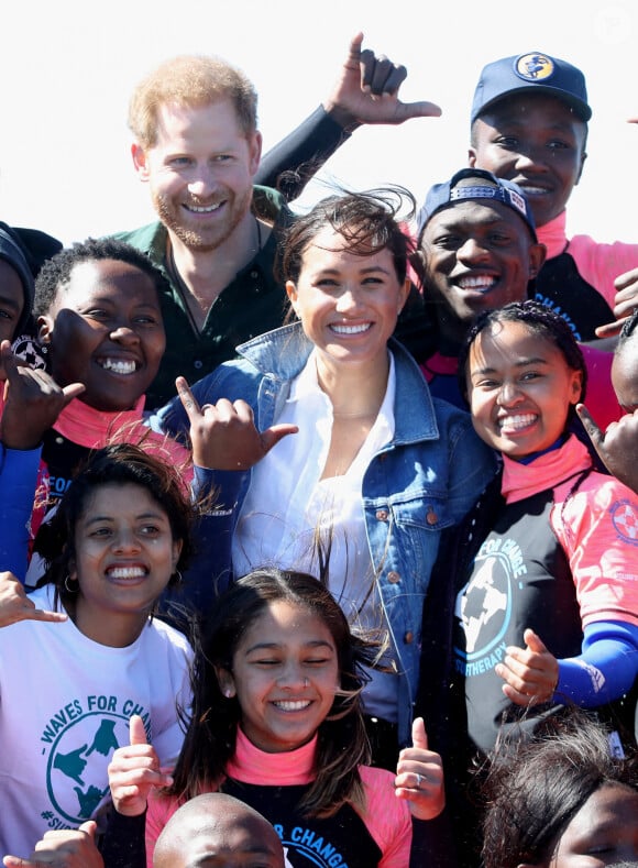 Le prince Harry, duc de Sussex, et Meghan Markle, duchesse de Sussex rencontrent les membres de "Waves for Change" un organisme de bienfaisance qui travaille avec les surfeurs locaux sur la plage de Monwabisi au Cap lors de leur 2ème journée en Afrique du Sud, le 24 septembre 2019.