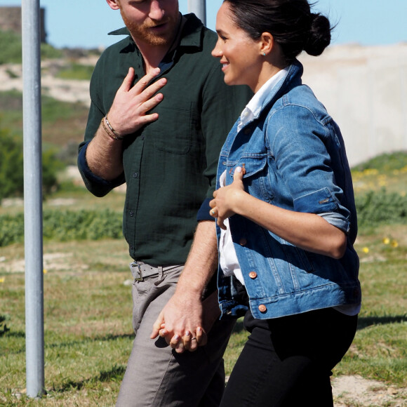 Le prince Harry, duc de Sussex, et Meghan Markle, duchesse de Sussex rencontrent les membres de "Waves for Change" un organisme de bienfaisance qui travaille avec les surfeurs locaux sur la plage de Monwabisi au Cap lors de leur 2ème journée en Afrique du Sud, le 24 septembre 2019.