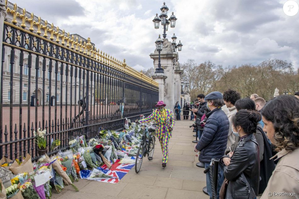 Les Anglais viennent rendrent hommage au prince Philip, duc d'Edimbourg devant les grilles de Buckingham Palace à Londres le 11 avril 2021.