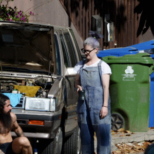 Exclusif - Kelly Osbourne aide son compagnon Erik Bragg à réparer sa voiture sur un trottoir de Los Angeles le 11 avril 2021.