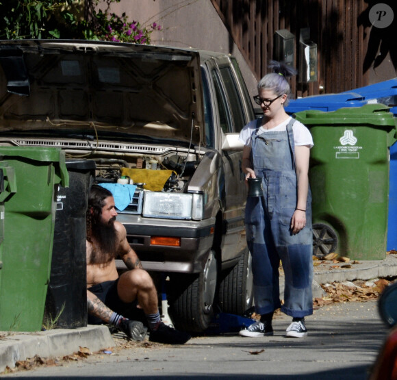 Exclusif - Kelly Osbourne aide son compagnon Erik Bragg à réparer sa voiture sur un trottoir de Los Angeles le 11 avril 2021.