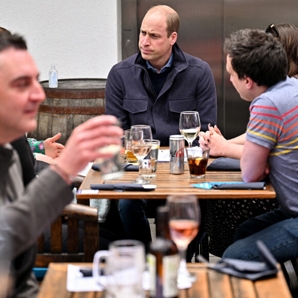 Le prince William, duc de Cambridge regarde la finale de la Coupe écossaise avec les intervenants d'urgence dans un bar sur le toit du Grassmarket à Edimbourg le 22 mai 2021.
