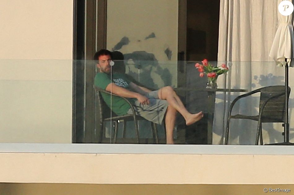 Ben Affleck fume une cigarette sur le balcon de la maison qu'il loue avec Jennifer Lopez à Miami le 25 mai 2021.