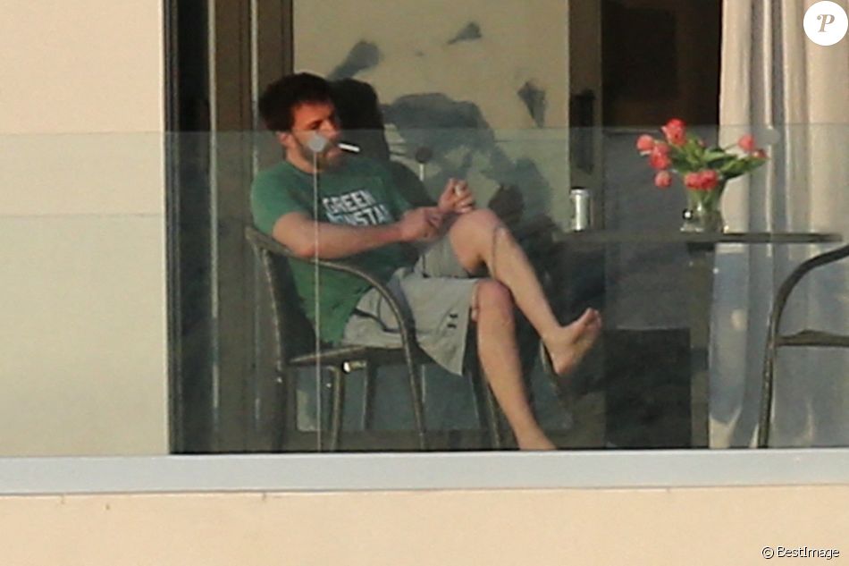 Ben Affleck fume une cigarette sur le balcon de la maison qu'il loue avec Jennifer Lopez à Miami le 25 mai 2021.