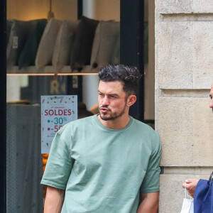Orlando Bloom attend sa fiancée Katy Perry devant le magasin Acne Studios. Paris, le 7 juillet 2021.