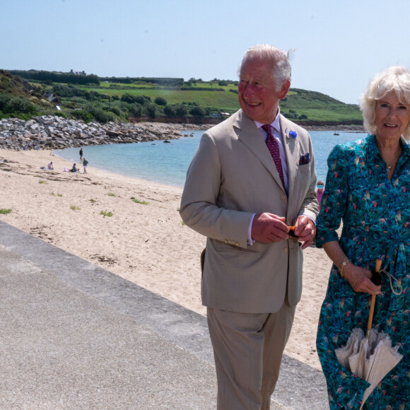 Le prince Charles et Camilla Parker Bowles, la duchesse de Cornouailles se promènent le long de la plage à St Mary's lors de leur visite aux îles Scilly, le 20 juillet 2021. 
