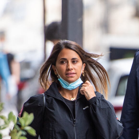 Antonella Roccuzzo (ensemble survêtement noir Adidas) sort de l'hôtel Royal Monceau .