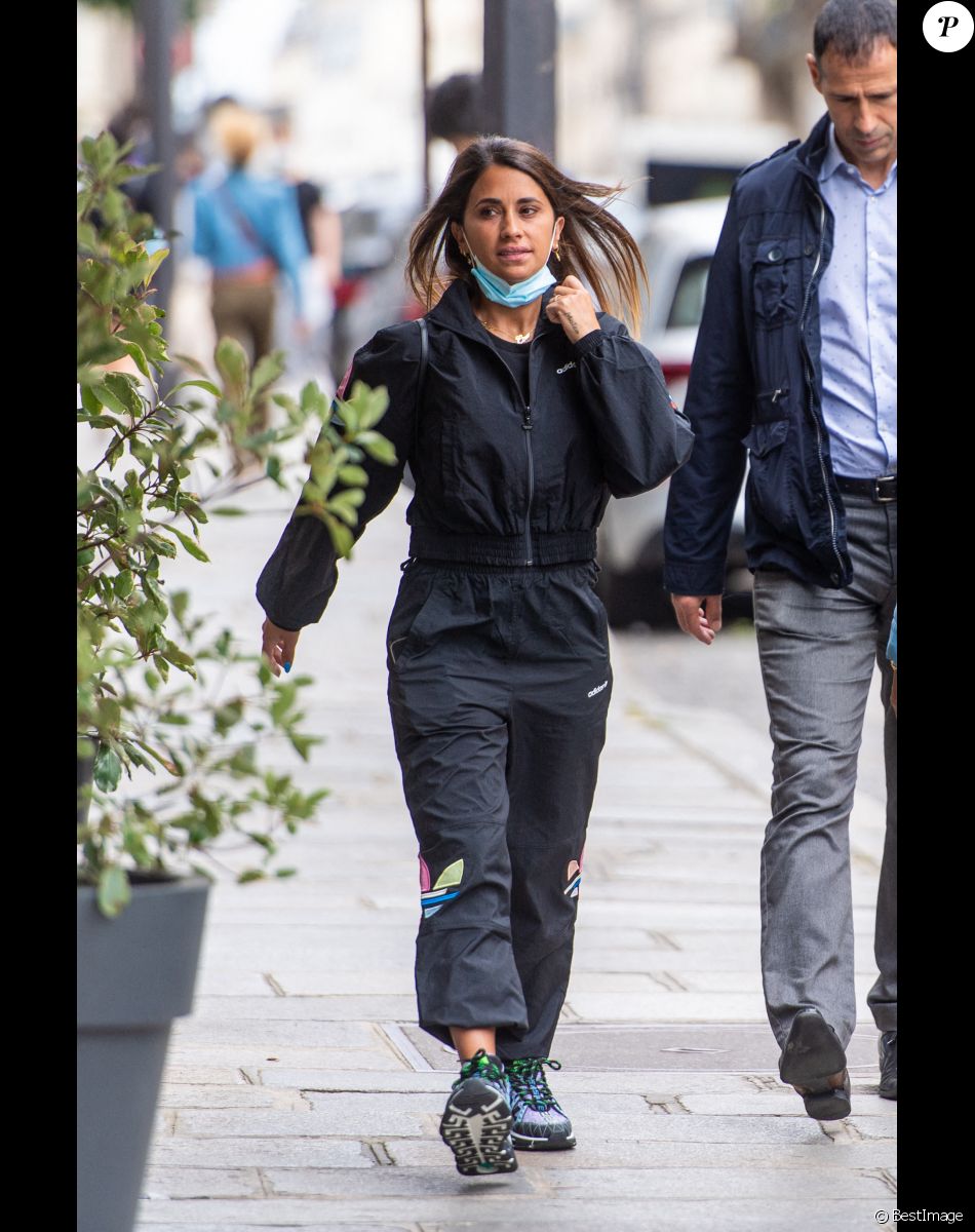 Antonella Roccuzzo (ensemble survêtement noir Adidas) sort de l'hôtel Royal Monceau .