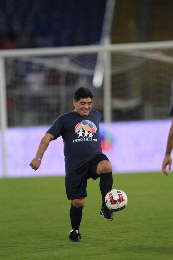 Diego Maradona jongle avec un ballon lors d'un match de football caritatif "United for Peace" au stade de Rome le 12 octobre 2014.