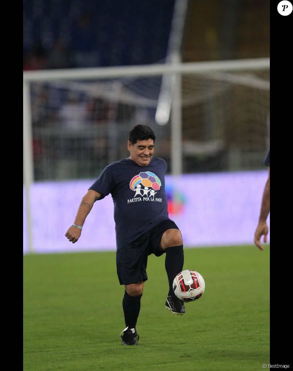 Diego Maradona jongle avec un ballon lors d'un match de football caritatif "United for Peace" au stade de Rome le 12 octobre 2014.