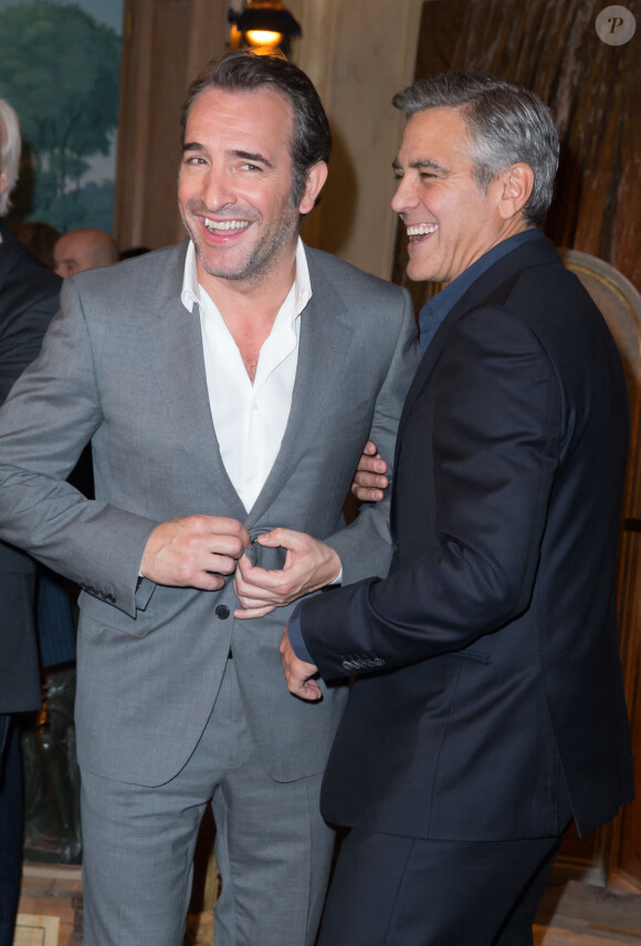 Jean Dujardin et George Clooney lors du photocall du film "Monuments Men" à l'hôtel Bristol à Paris le 12 février 2004. 