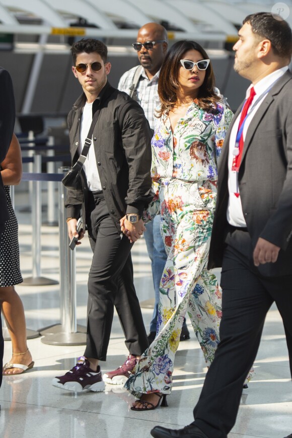 Nick Jonas et sa femme Priyanka Chopra se tiennent la main en arrivant à l'aéroport JFK à New York. Le 27 juillet 2019.