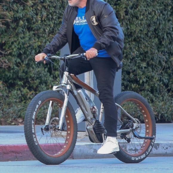 Arnold Schwarzenegger se rend à la salle de gym en vélo avec des amis à Santa Monica le 26 janvier 2022. 