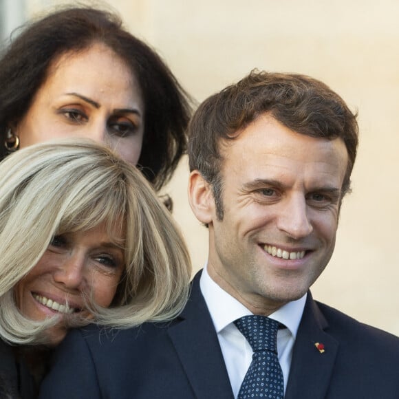 Le président de la République française, Emmanuel Macron et sa femme la Première Dame, Brigitte Macron posent pour une photo de groupe avec les premières lauréates de l'Initiative Marianne pour les défenseurs des droits de l'homme à la suite d'une cérémonie de remise de prix dans le cadre de la journée internationale de la femme, au palais de l'Elysée à Paris, France, le 8 mars 2022