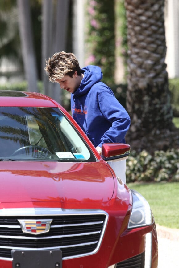 Cruz Beckham se déplace en voiture de golf avec un ami avant le mariage de son frère Brooklyn à Miami le 9 avril 2022. 