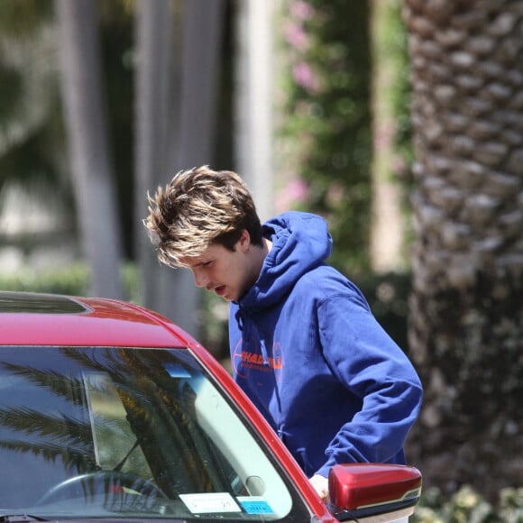 Cruz Beckham se déplace en voiture de golf avec un ami avant le mariage de son frère Brooklyn à Miami le 9 avril 2022. 