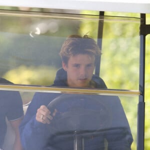 Cruz Beckham se déplace en voiture de golf avec un ami avant le mariage de son frère Brooklyn à Miami le 9 avril 2022. 