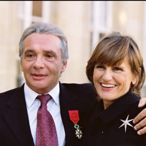 Michel Sardou reçoit la légion d'honneur à l'Elysée en 2001 avec sa femme Anne-Marie Périer