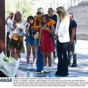 Laeticia Hallyday et ses filles Jade et Joy sont allées déposer des fleurs au pied de la statue de Johnny Hallyday, sur le parvis de la salle AccorHotels Arena à Paris. Le 15 juin 2022.