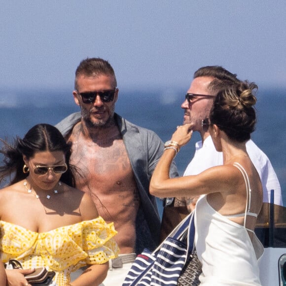 David Beckham, sa femme Victoria et leurs enfants, Harper et Cruz avec sa compagne Tana Holding arrivent en bateau avec des amis dont le coach sportif Bobby Rich sur la plage des Salins à Saint-Tropez où ils vont passer l'après-midi dans une résidence privée le 23 juillet 2022.