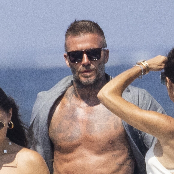 David Beckham, sa femme Victoria et leurs enfants, Harper et Cruz avec sa compagne Tana Holding arrivent en bateau avec des amis dont le coach sportif Bobby Rich sur la plage des Salins à Saint-Tropez où ils vont passer l'après-midi dans une résidence privée le 23 juillet 2022.