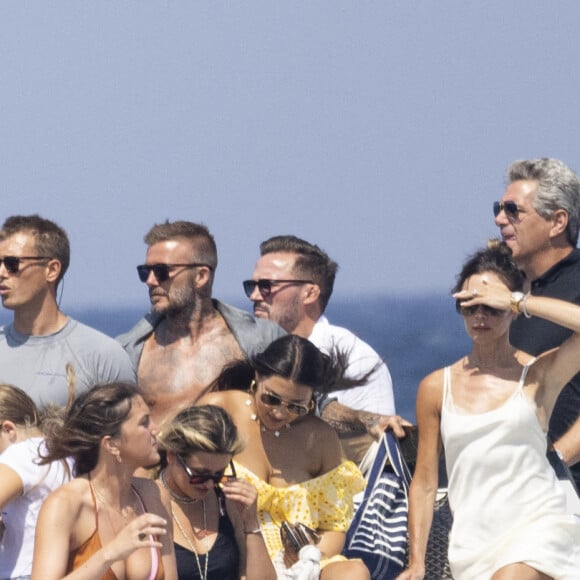 David Beckham, sa femme Victoria et leurs enfants, Harper et Cruz avec sa compagne Tana Holding arrivent en bateau avec des amis dont le coach sportif Bobby Rich sur la plage des Salins à Saint-Tropez où ils vont passer l'après-midi dans une résidence privée le 23 juillet 2022.