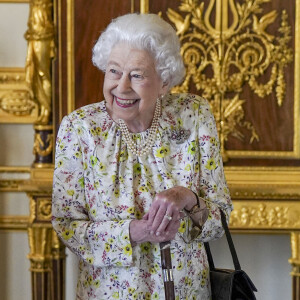 La reine Elisabeth II d'Angleterre parcourt l'exposition d'objets de la société d'artisanat britannique Halcyon Days, pour marquer son jubilé de platine, au château de Windsor, le 23 mars 2022. 