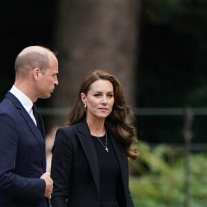 Le prince William et Kate Middleton regardent les hommages floraux laissés par les membres du public aux portes de Sandringham House à Norfolk, Royaume Uni, le 15 septembre 2022.