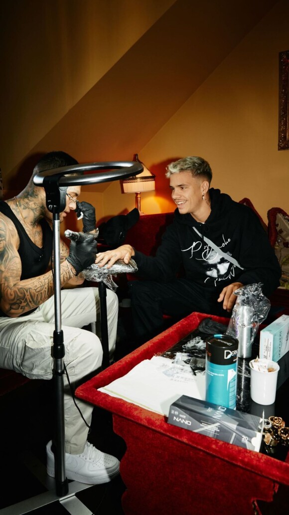 Romeo Beckkham se fait tatouer avant d'assister au défilé de sa mère Victoria Beckham. Le 30 septembre 2022.