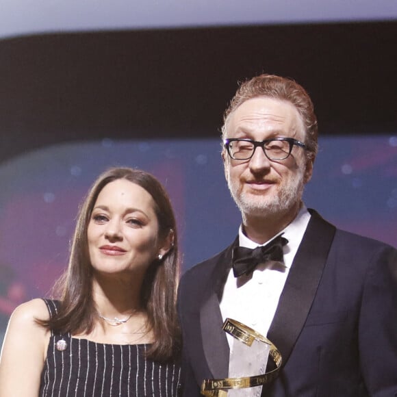 James Gray reçoit des mains de Marion Cotillard l'étoile d'or à l'occasion de l'hommage qui lui est rendu lors du 19e Festival International du Film de Marrakech, le 12 novembre 2022. © Denis Guignebourg / Bestimage