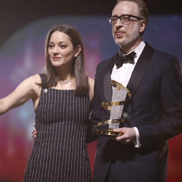James Gray reçoit des mains de Marion Cotillard l'étoile d'or à l'occasion de l'hommage qui lui est rendu lors du 19e Festival International du Film de Marrakech, le 12 novembre 2022. © Denis Guignebourg / Bestimage