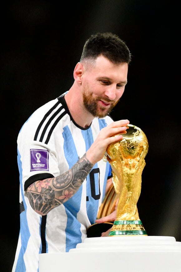 Lionel Messi qui vient embrasser le trophee de la Coupe du Monde - Remise du trophée de la Coupe du Monde 2022 au Qatar (FIFA World Cup Qatar 2022) à l'équipe d'argentine après sa victoire contre la France en finale (3-3 - tab 2-4). Doha, le 18 décembre 2022.