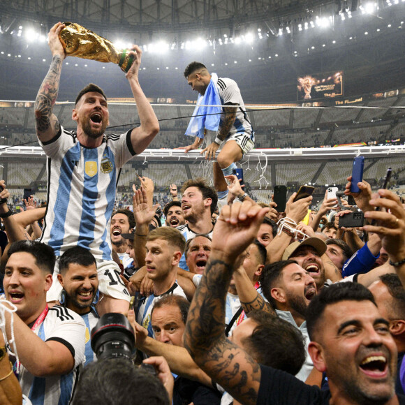 Lionel Messi et ses co-équipiers lors de la remise du trophée de la Coupe du Monde 2022 au Qatar (FIFA World Cup Qatar 2022) à l'équipe d'Argentine qui s'est imposée face à la France (3-3 - tab 2-4). L'Argentine remporte sa troisième Coupe du Monde. Doha, le 18 décembre 2022.