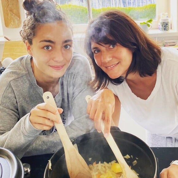 Estelle Denis cuisine le poulet au citron façon tajine de Cyril Lignac avec sa fille Victoire dans la cuisine de leur maison en Bretagne, où Estelle Denis et Raymond Domenech sont confinés avec leurs deux enfants. Le 8 avril 2020.