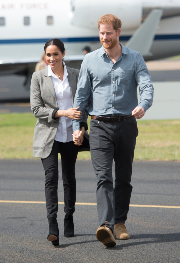 Le prince Harry, duc de Sussex, et Meghan Markle (enceinte), duchesse de Sussex, à leur arrivée à l'aéroport de Dubbo, à l'occasion de leur voyage officiel en Australie.
